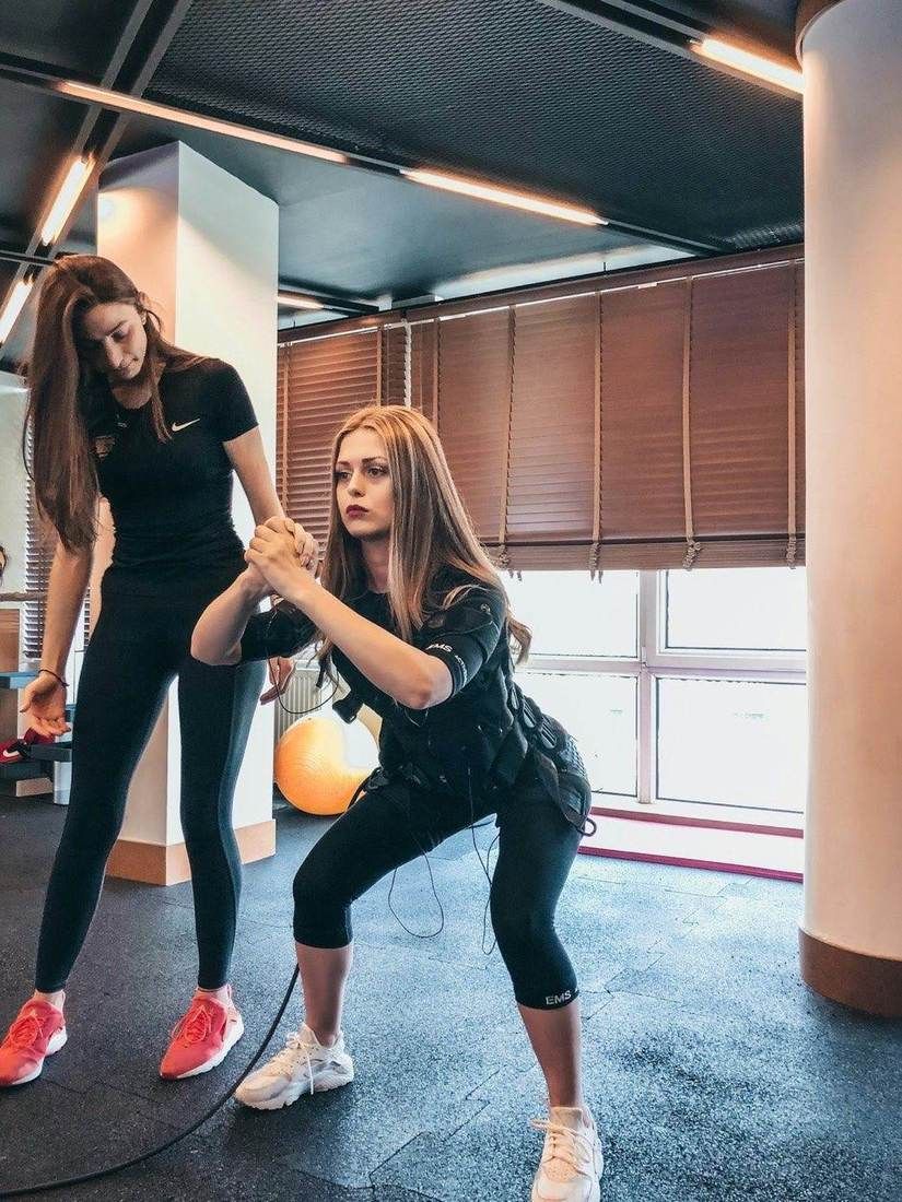 Deux personnes s’entraînent dans un studio de fitness aux grandes baies vitrées.